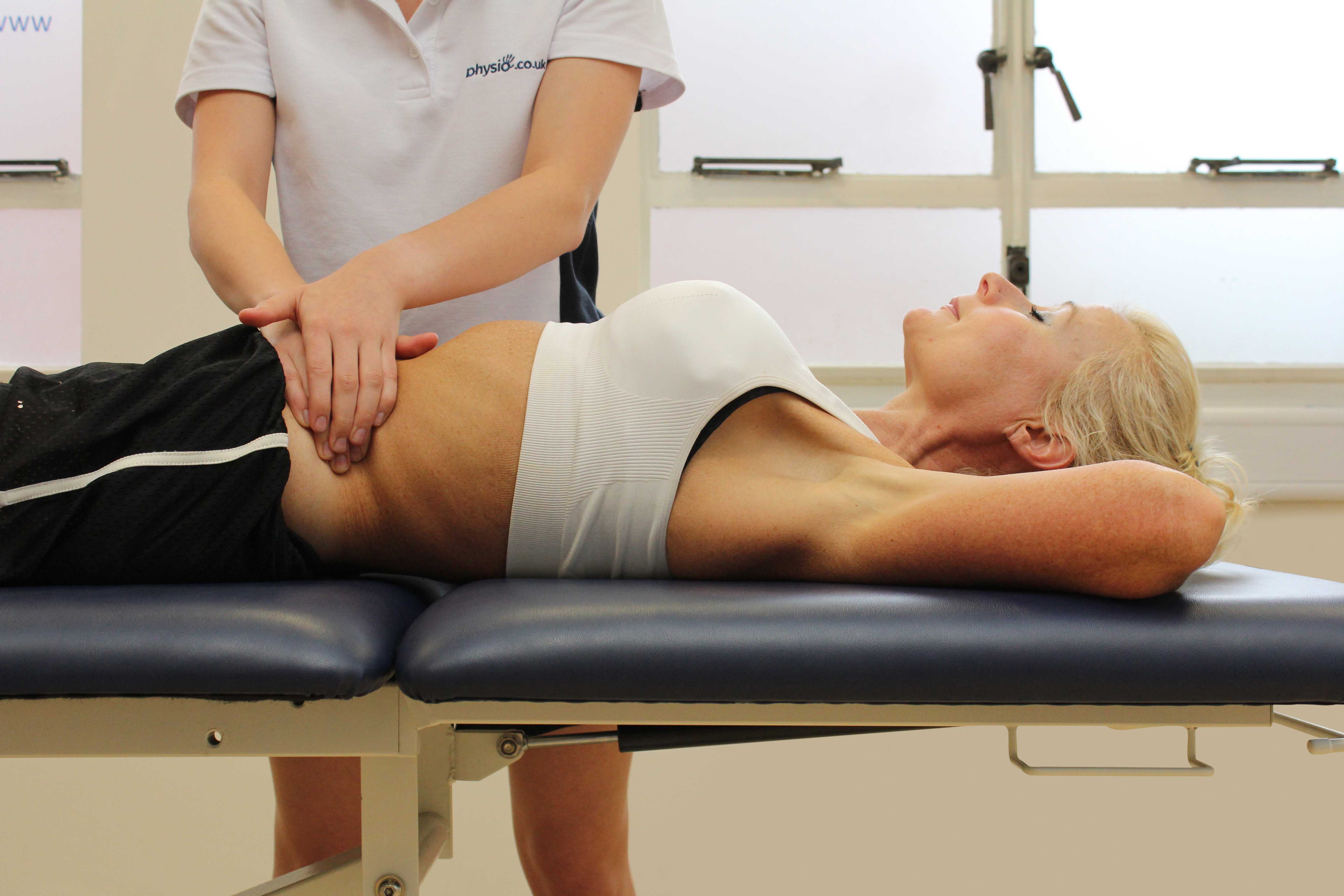 Soft tissue massage of the abdominal muscles by an experienced therapist