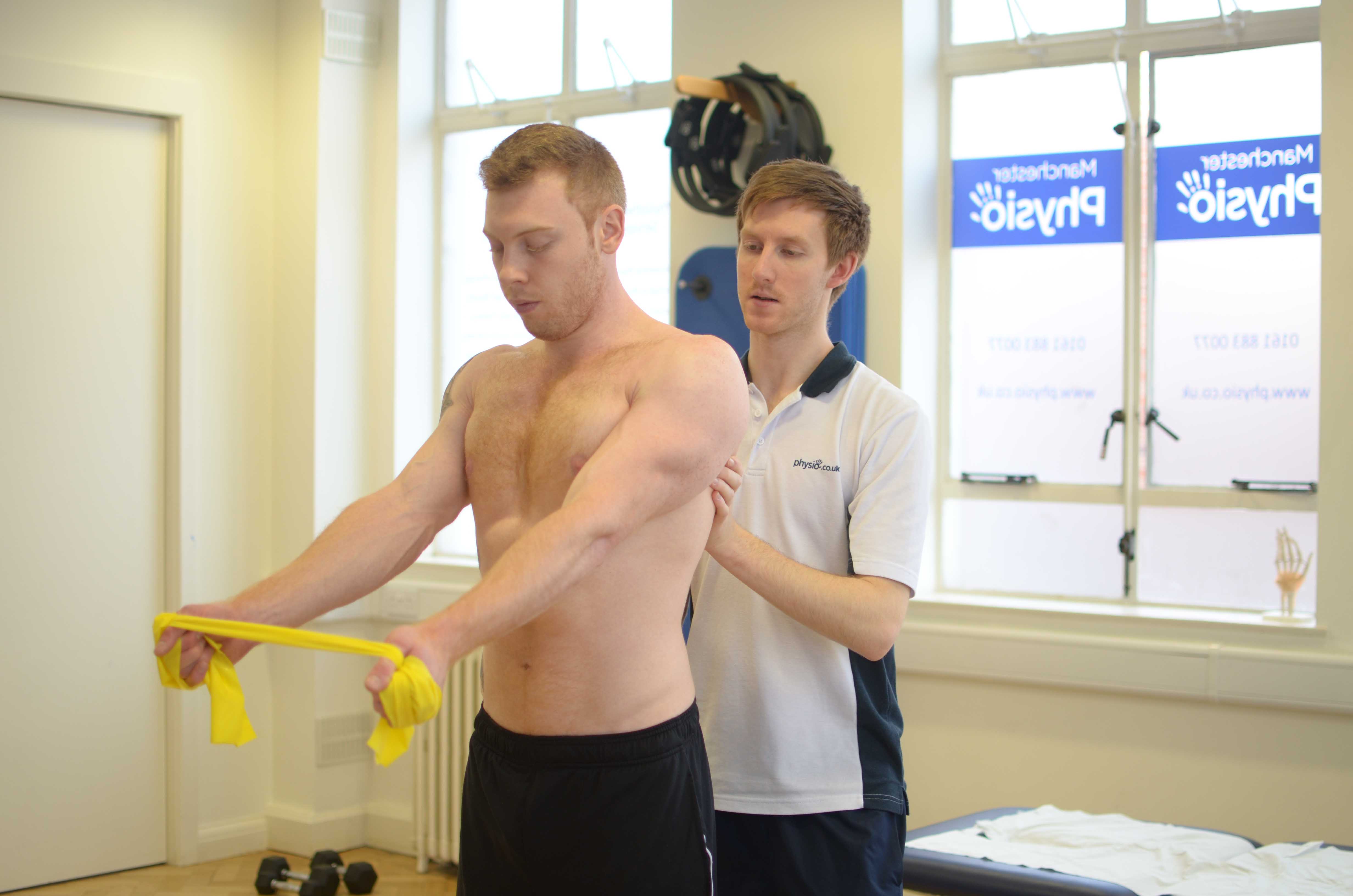Physiotherapist supervising isometric exercises to alleviate pain Physiotherapist supervising isometric exercises to alleviate pain