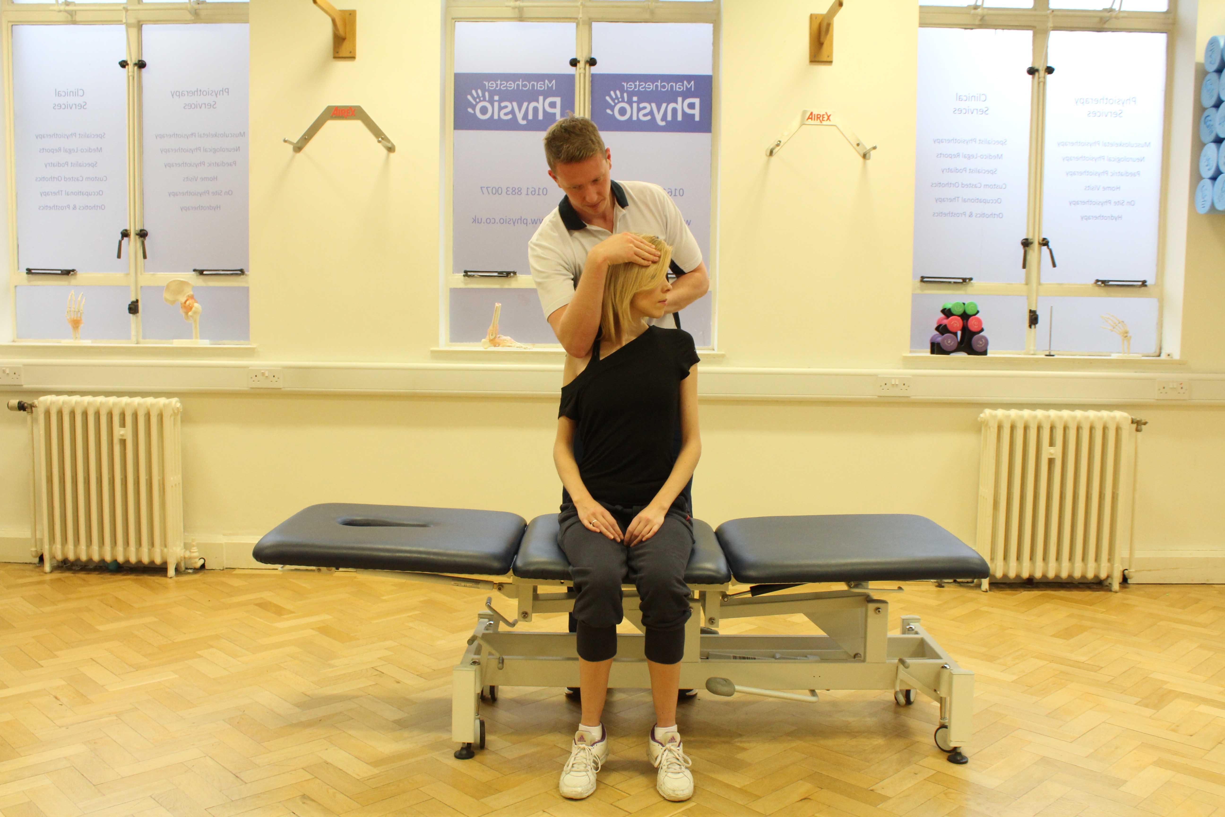 Experienced Physiotherapist conducting an assessment of the cervical spine, muscles and connective tissues in the neck Experienced Physiotherapist conducting an assessment of the cervical spine, muscles and connective tissues in the neck