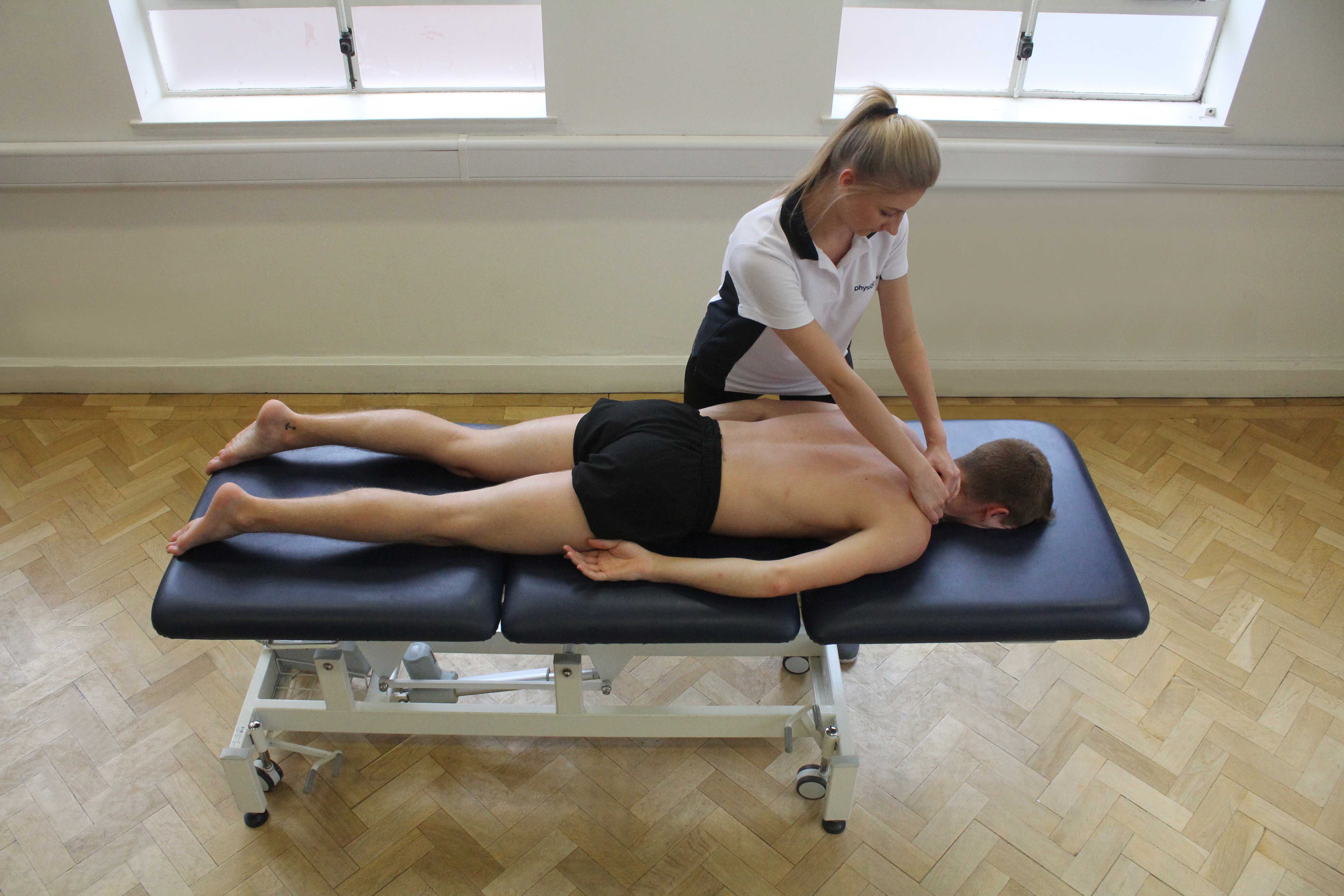 Deep tissue massage of the trapezius muscle by the therapist
