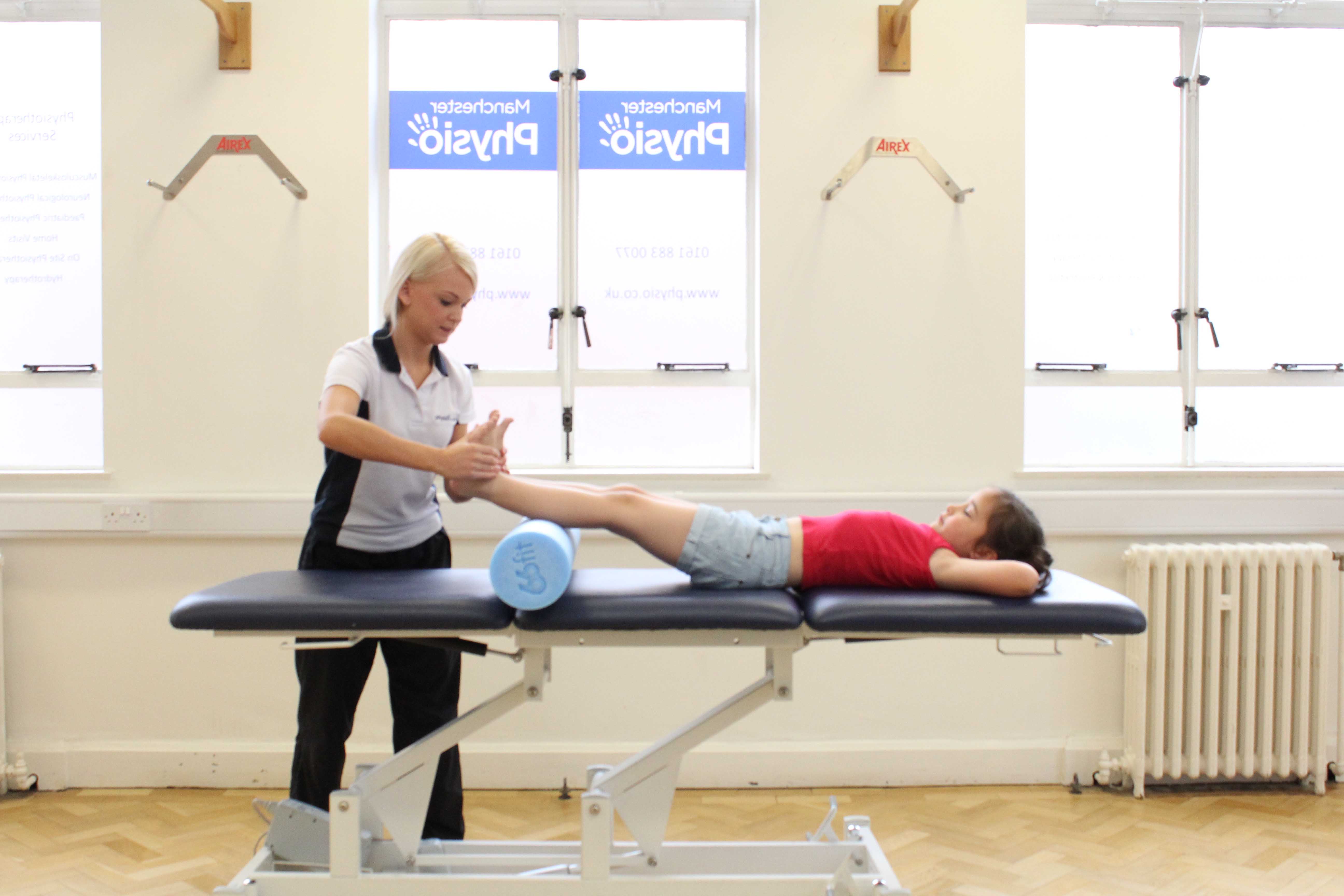 Therapist applies foot dorsiflex stretch to patient Therapist applies foot dorsiflex stretch to patient