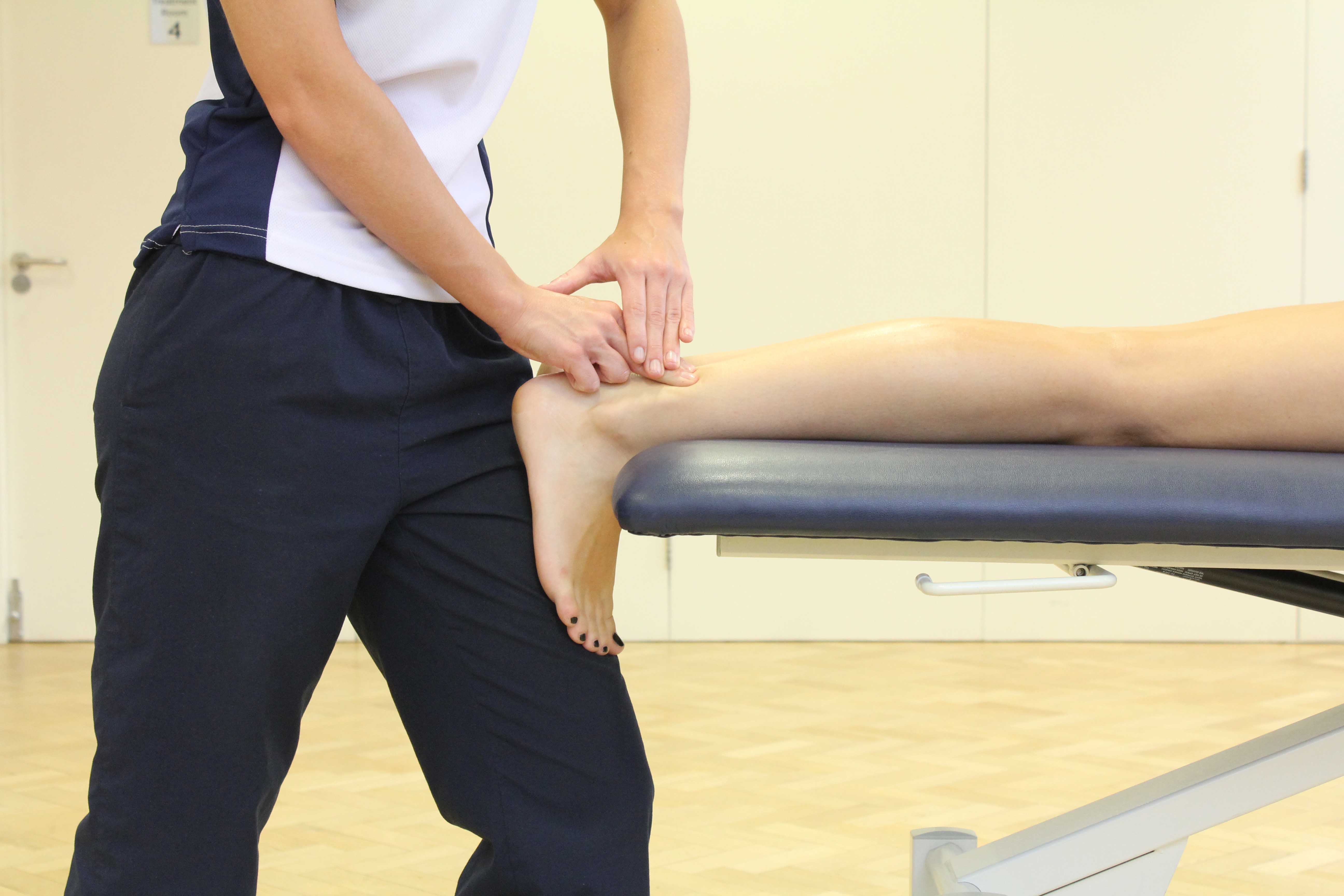 Soft tissue massage of the achilles tendon by experienced physiotherapist