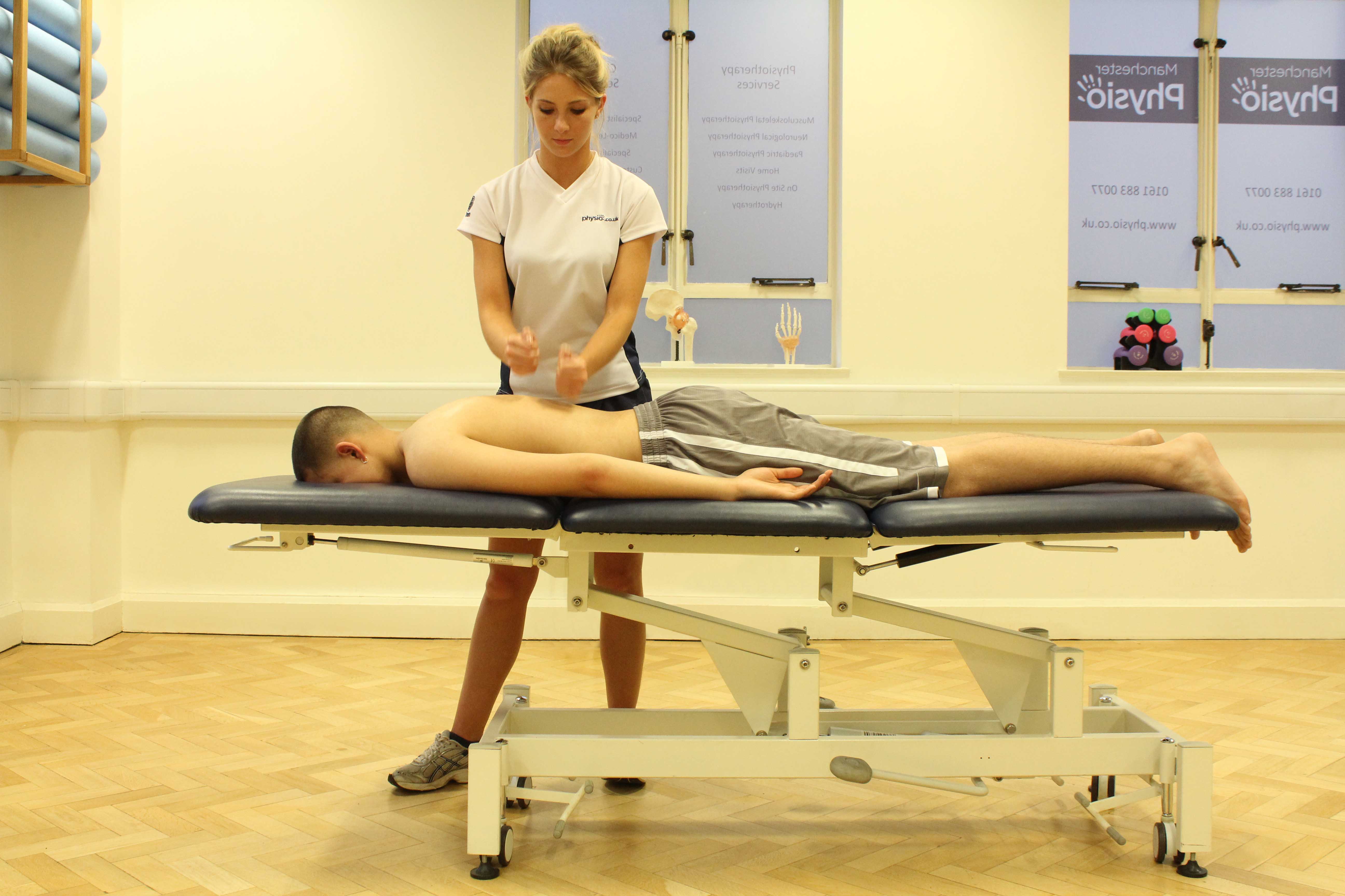 Percussion massage applied to the mid thoracic spine Percussion massage applied to the mid thoracic spine