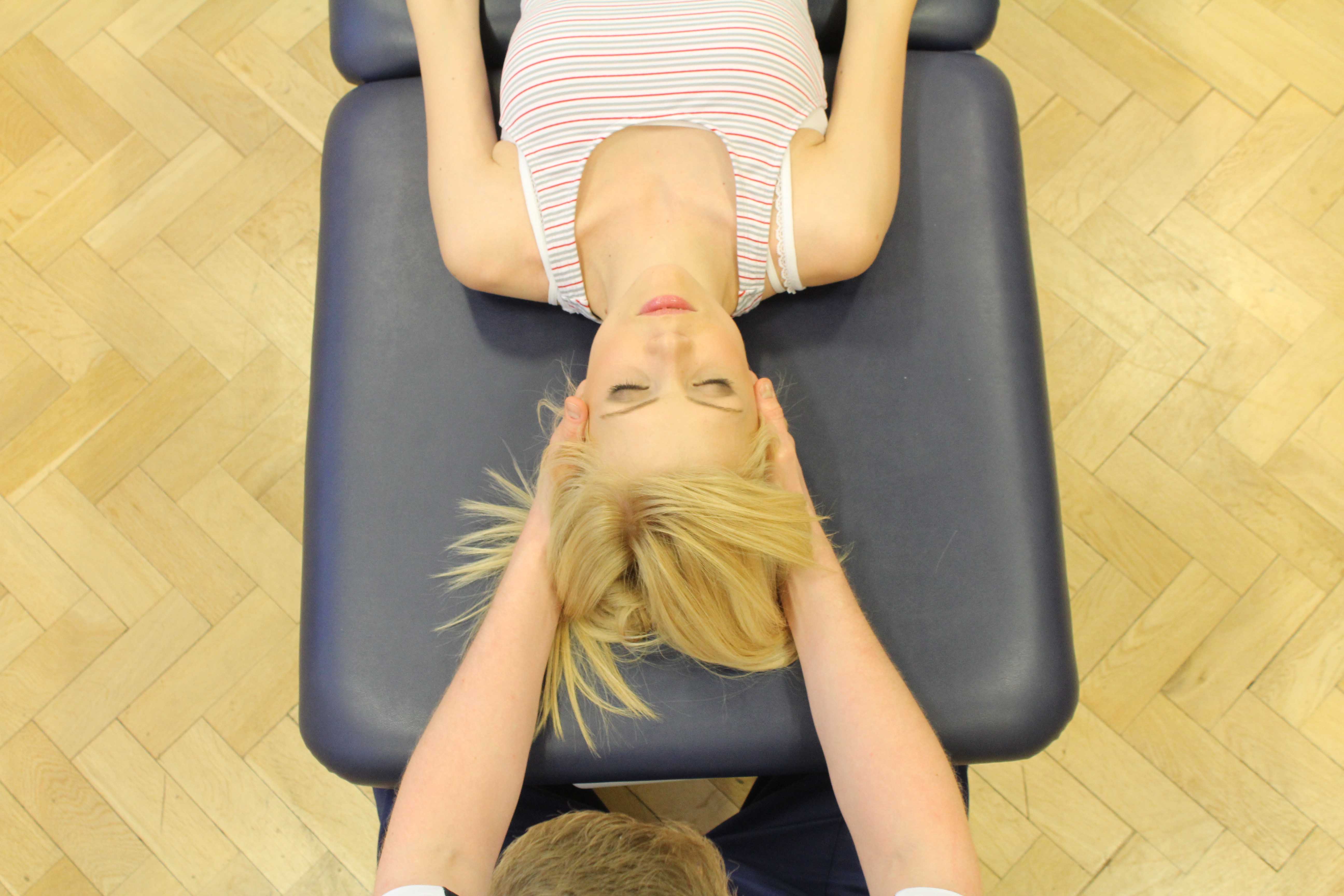 Experienced Physiotherapist conducting an assessment of the cervical spine, muscles and connective tissues in the neck