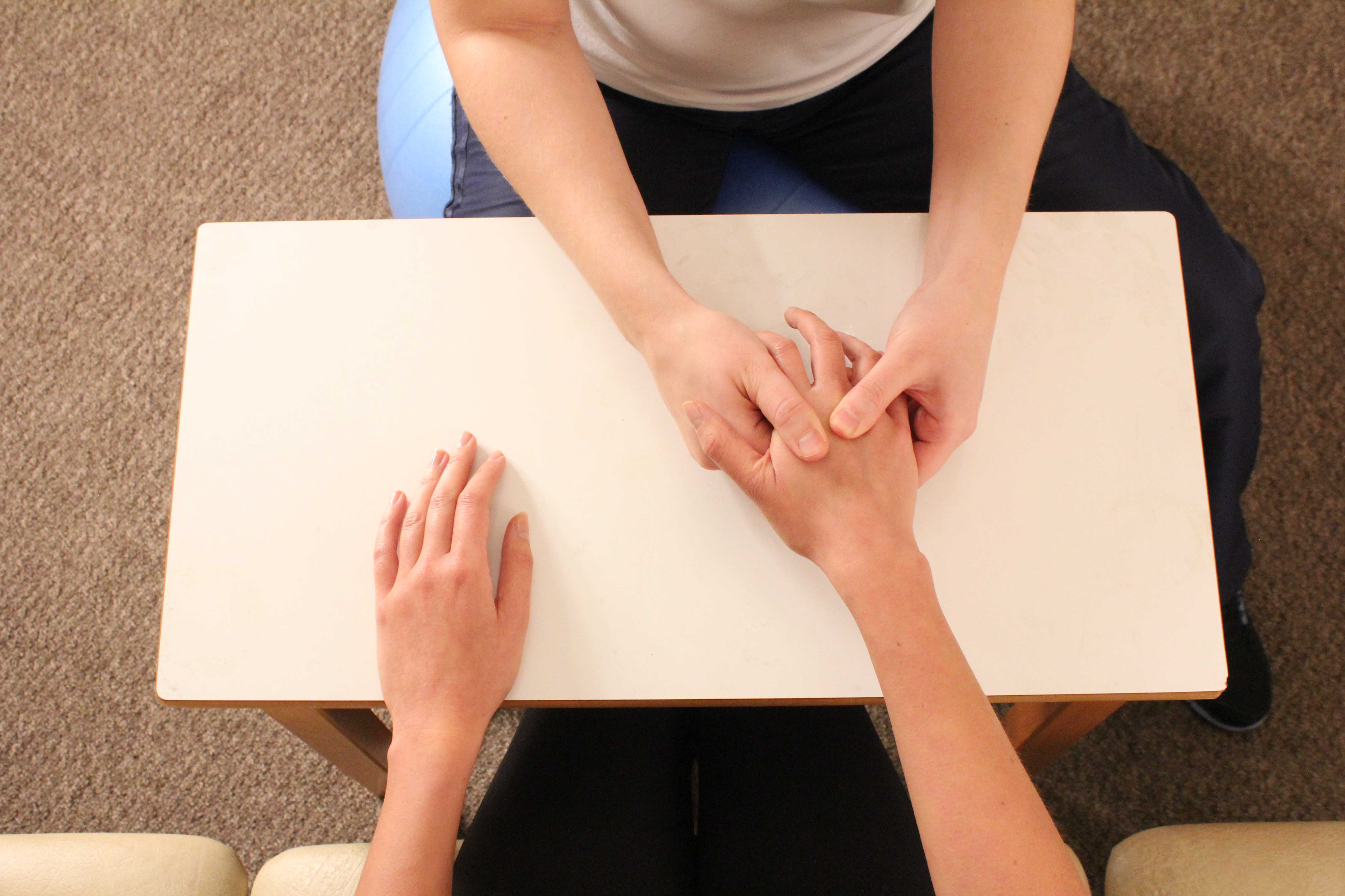 Therapist soft tissue massage of the metacarpals and connective tissues in the hand
