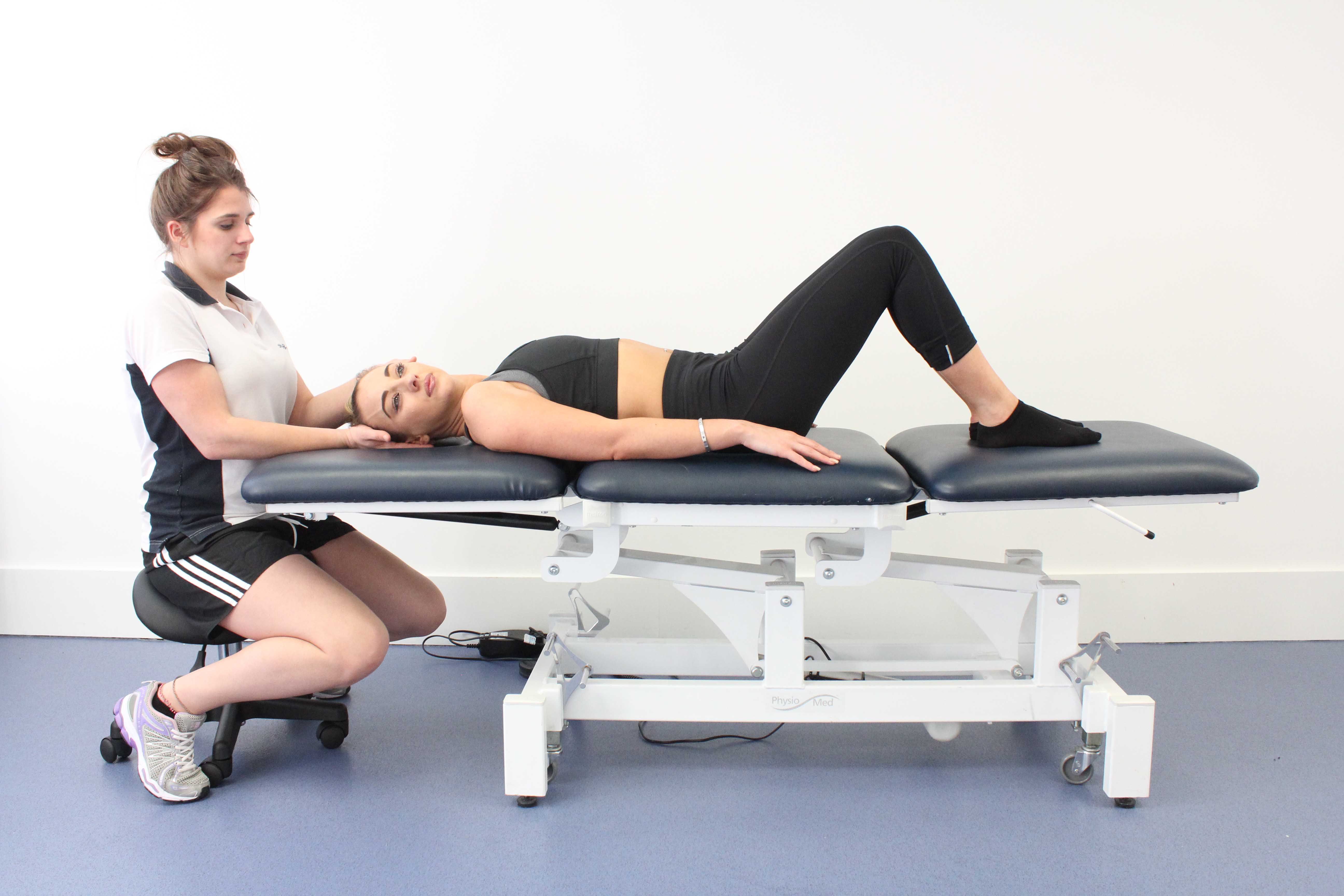 Physiotherapist performing postural realignment exercises to correct vestibular balance and dizziness conditions