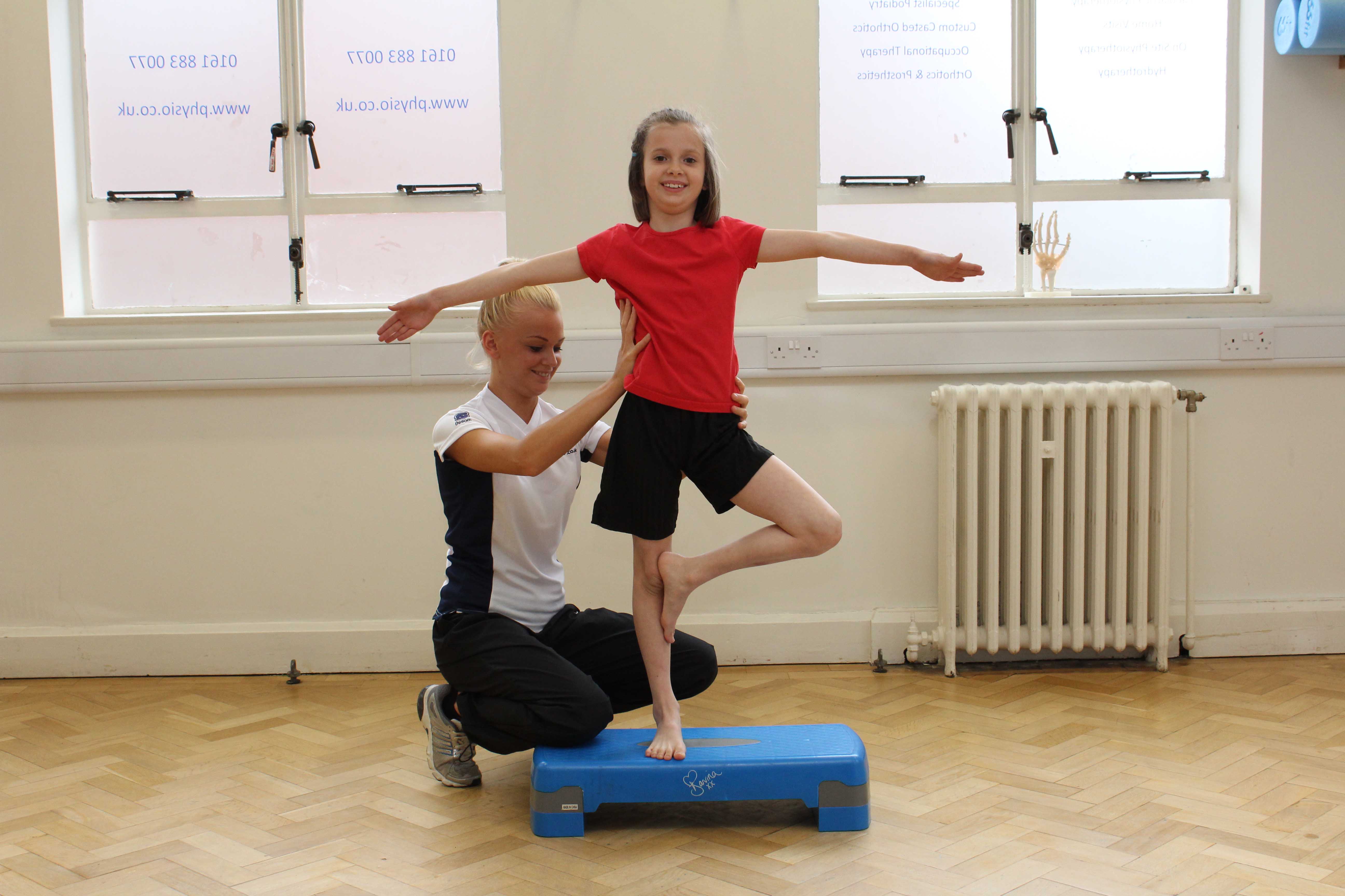 Therapist assists during progressive balance training exercises Therapist assists during progressive balance training exercises