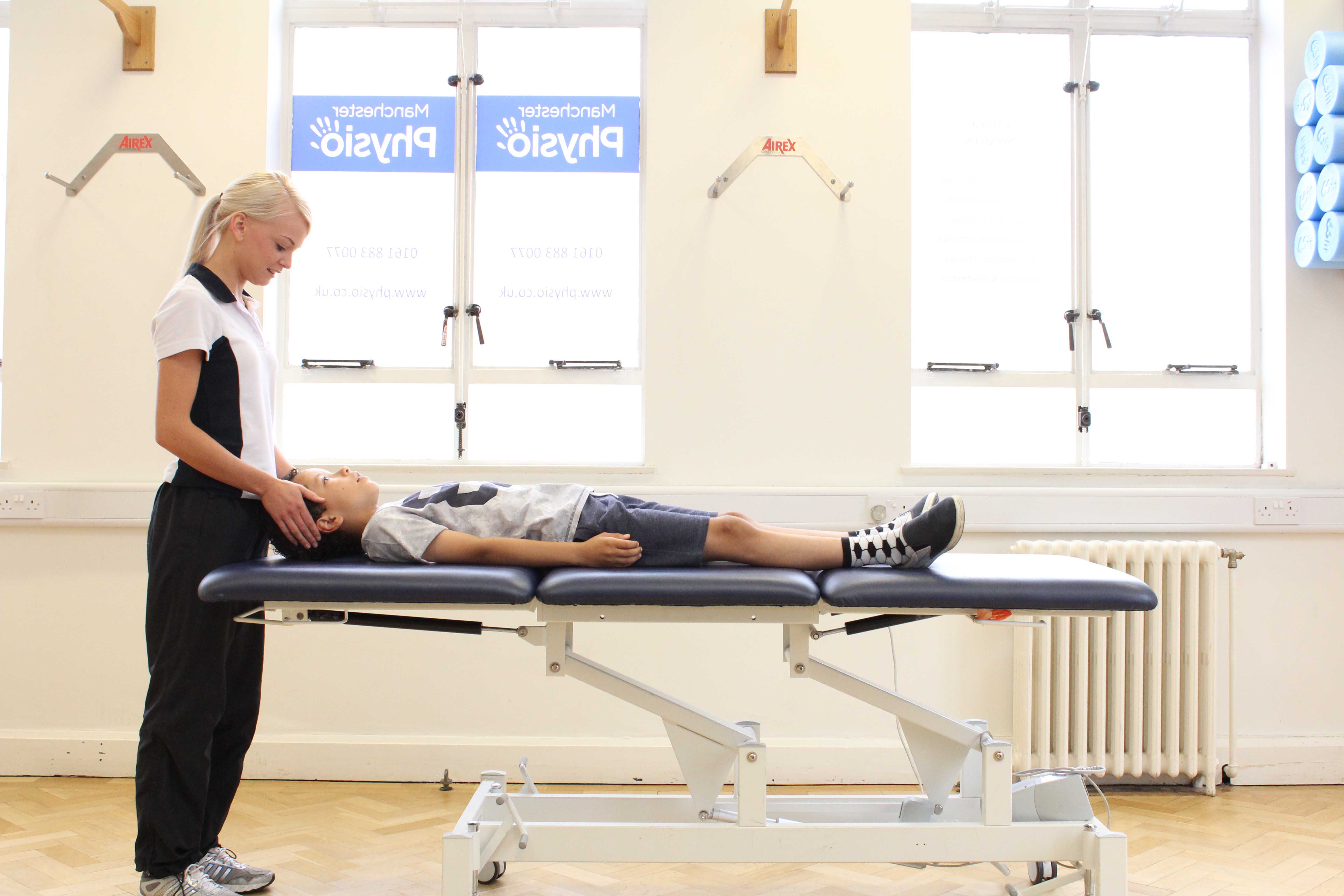 Physiotherapist facilitating a gripping exercise designed to promote independance Physiotherapist facilitating a gripping exercise designed to promote independance