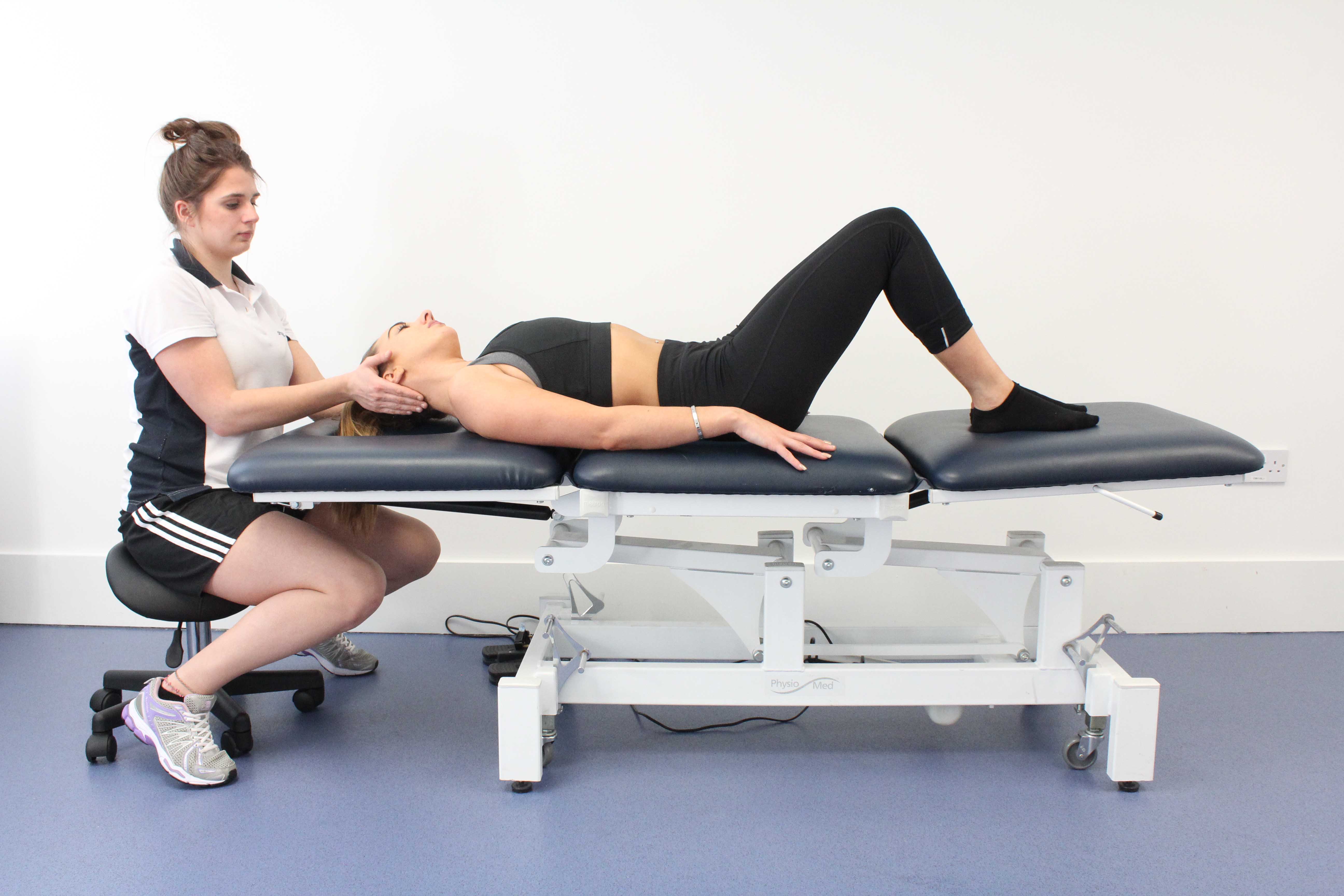 Physiotherapist performing postural realignment exercises to correct vestibular balance and dizziness conditions Physiotherapist performing postural realignment exercises to correct vestibular balance and dizziness conditions