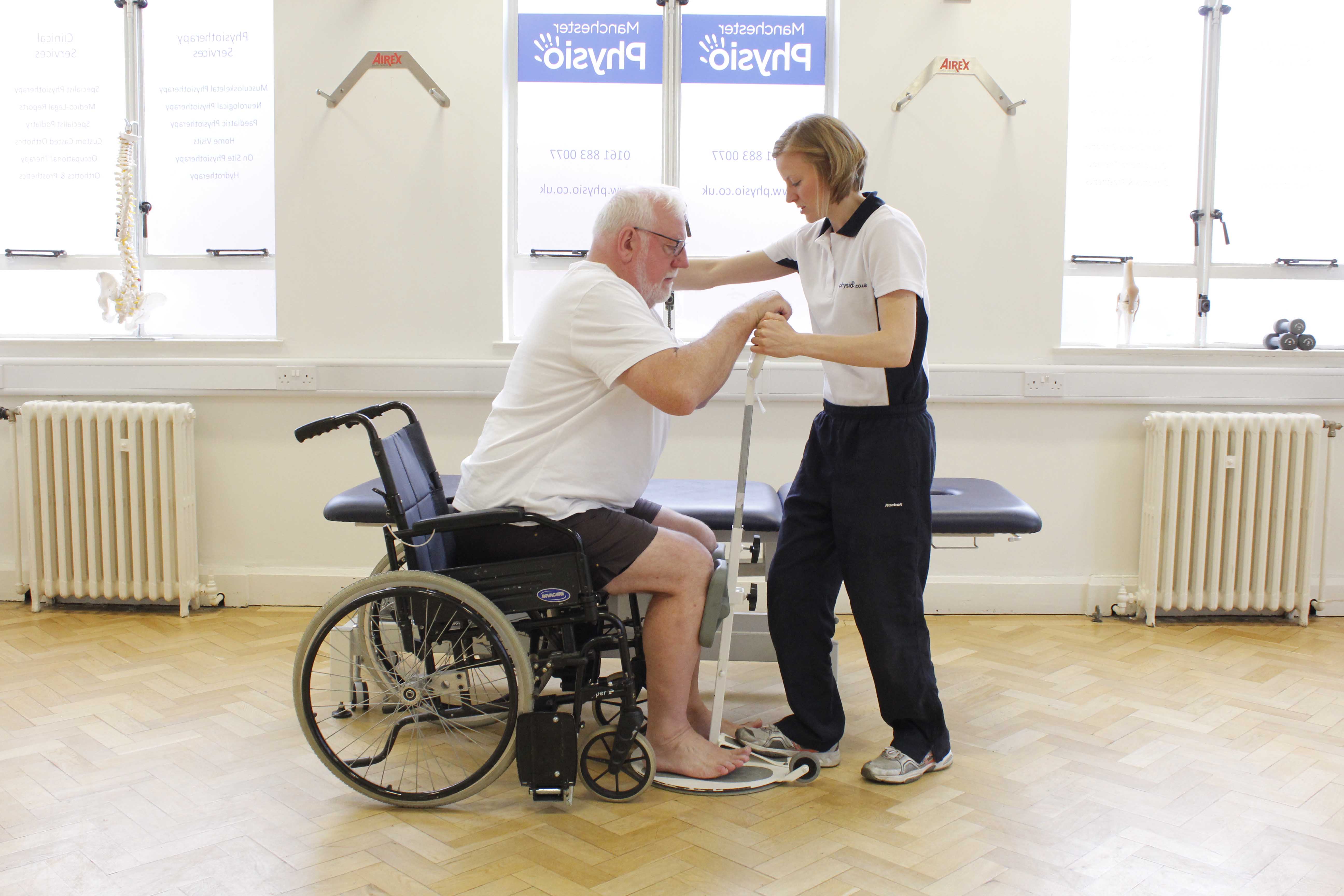 Neurological physiotherapist assisting mobility transfers using a pivot standing frame Neurological physiotherapist assisting mobility transfers using a pivot standing frame