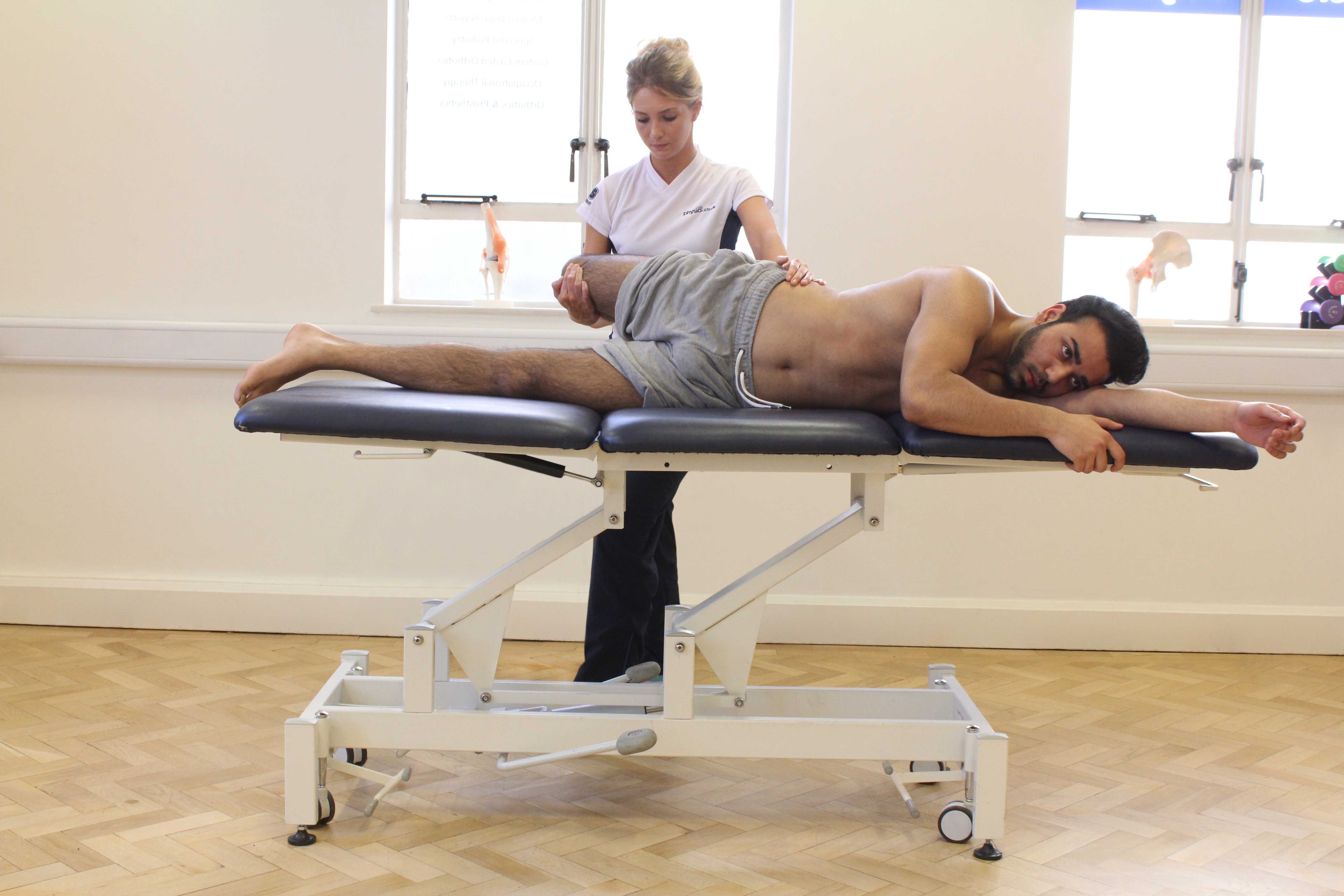 Therapist applying stretch to hip flexor and quad muscle groups Therapist applying stretch to hip flexor and quad muscle groups
