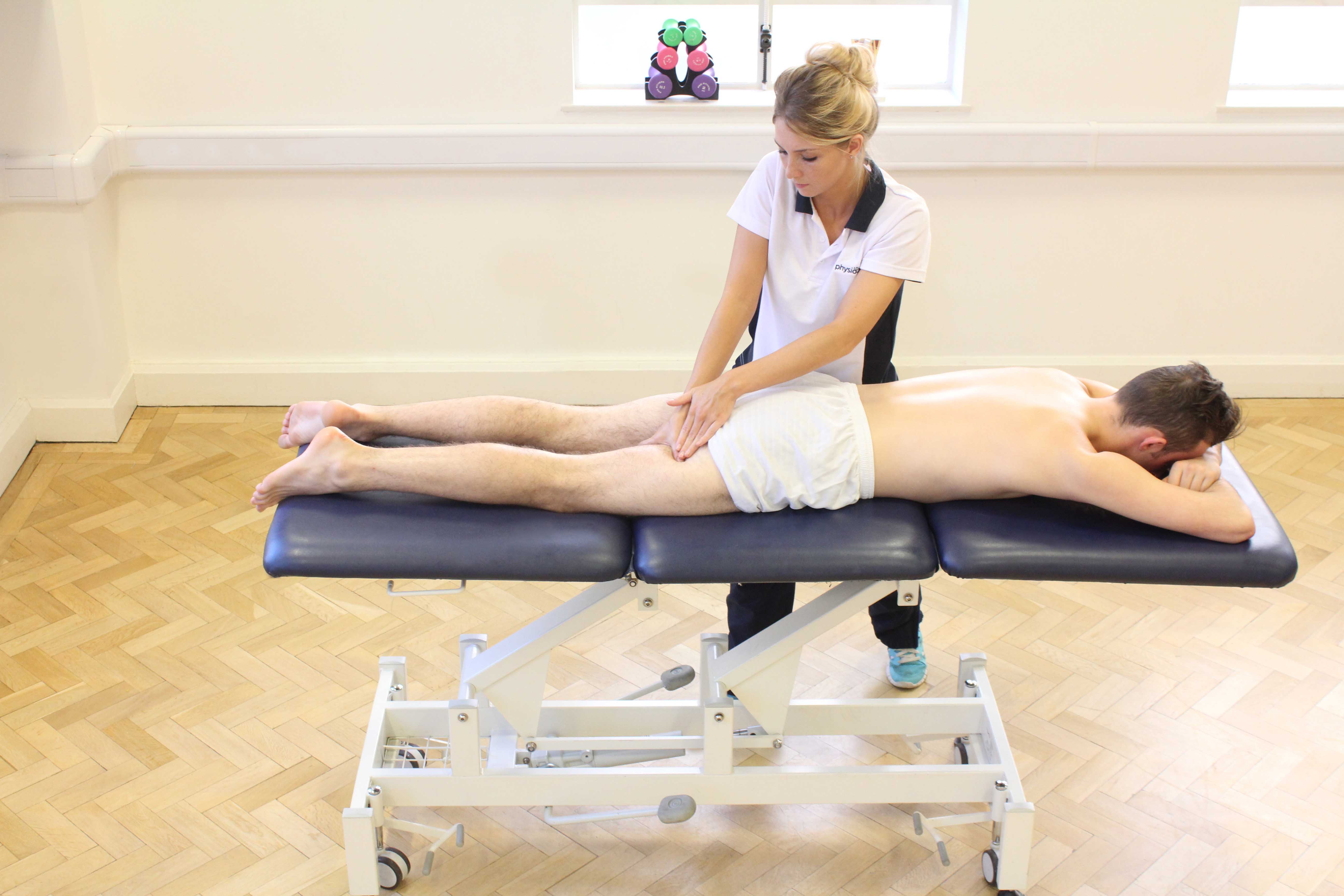 Soft tissue massage of the hamstring muscles to clear excess fluid