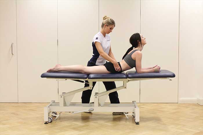 Customer aided with back stretches by instructor in Manchester Physio Clinic