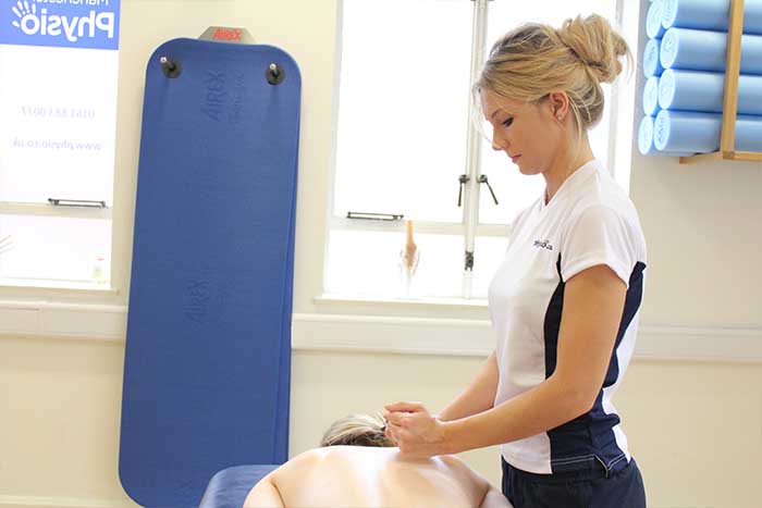 Customer reciving an upper back massage while in a relaxed position in Manchester Physio Clinic Customer reciving an upper back massage while in a relaxed position in Manchester Physio Clinic