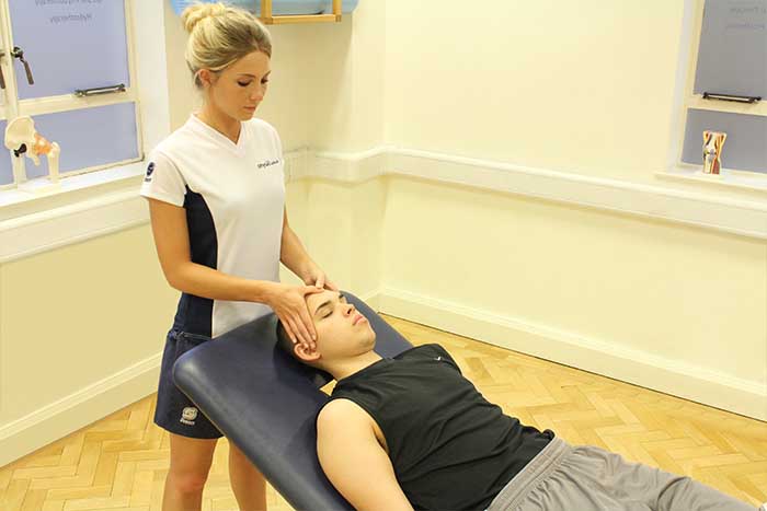 Customer receiving jaw massage while in a relaxed position in Manchester Physio Clinic Customer receiving jaw massage while in a relaxed position in Manchester Physio Clinic