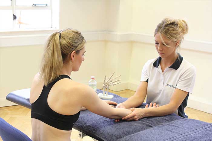 Customer given an arm massage while in a sottong position in Manchester Physio Clinic