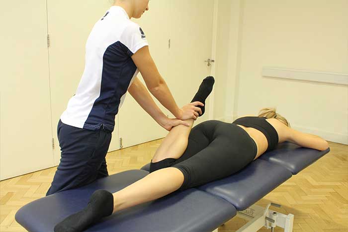 Customer reciving calf massage while in relaxed position in Manchester Physio Clinic