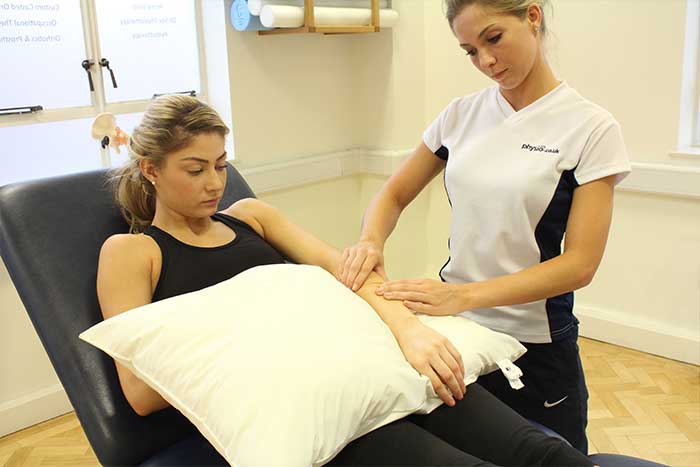 Customer receiving arm checks during massagein Manchester Physio Clinic