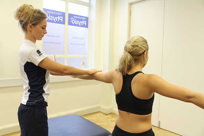 Customer reciving arm massage, while stretching in Manchester Physio Clinic Customer reciving arm massage, while stretching in Manchester Physio Clinic