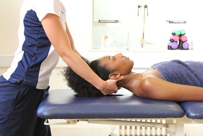 Customer receiving neck massage to decrease body tension in Manchester Physio Clinic