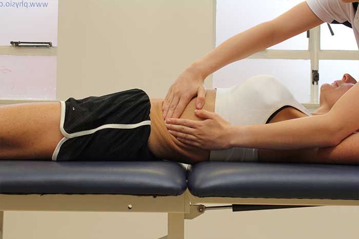 Customer receiving abdominal massage while in a relaxed position in Manchester Physio Clinic