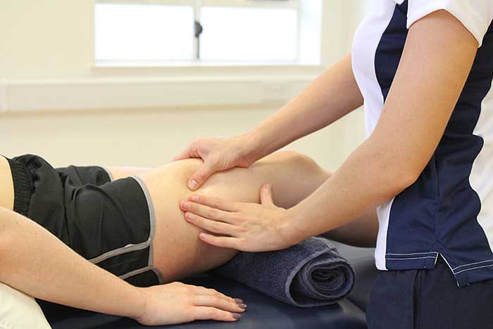 Customer receiving thigh massage while in a relaxed position in Manchester Physio Clinic