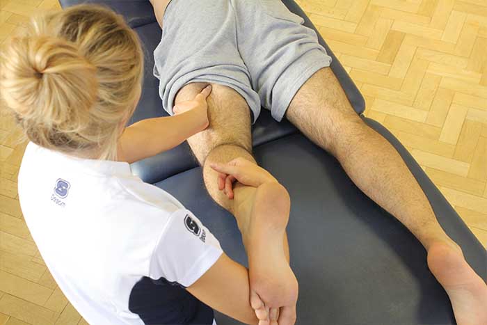 Customer receiving leg stretch massage while in a relaxation position in Manchester Physio Clinic