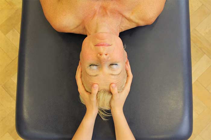 Customer reciving face massage while in relaxed position in Manchester Physio Clinic