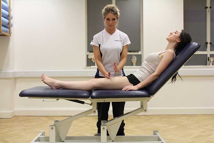Customer reciving thigh massage using hacking technique in Manchester Physio Clinic