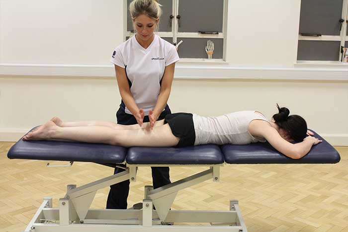 Customer reciving thigh massage using hacking technique in Manchester Physio Clinic