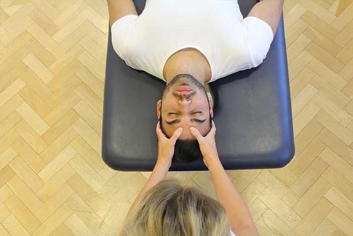 Customer reciving a head massage while in a relaxed position