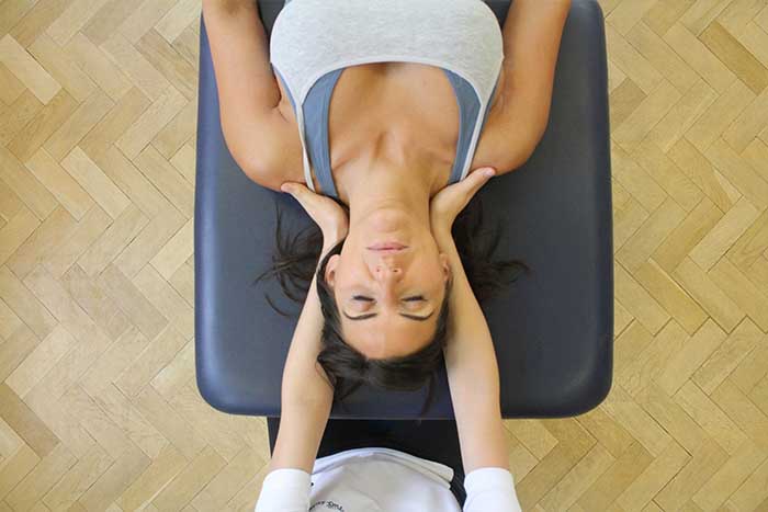 Customer reciving a head massage while in a relaxed position in Manchester Physio Clinic