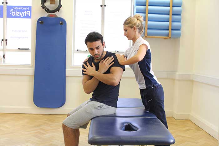 Customer receiving upper back massage in a sitting up position in Manchester Physio Clinic Customer reciving upper back massage in a sitting up position in Manchester Physio Clinic