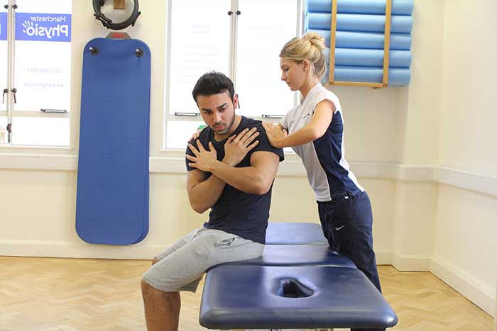 Customer reciving upper back massage in a sitting up position in Manchester Physio Clinic 