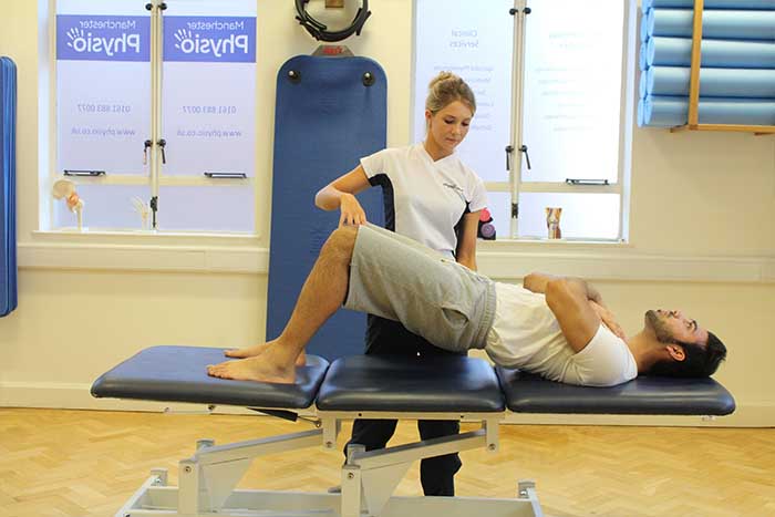Customer increasing flexibility in Manchester Physio Clinic Customer increasing flexibility Customer maintaining back stretches in Manchester Physio Clinic in Manchester Physio Clinic