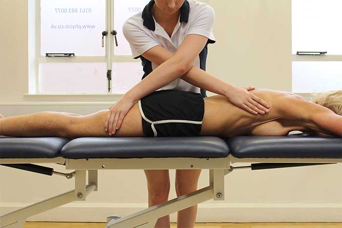 Customer receiving a thigh massage while in a relaxed position in Manchester Physio Clinic