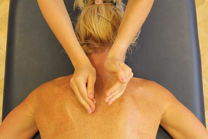 Customer receiving an upper back massage while in a relaxed position in Manchester Physio Clinic