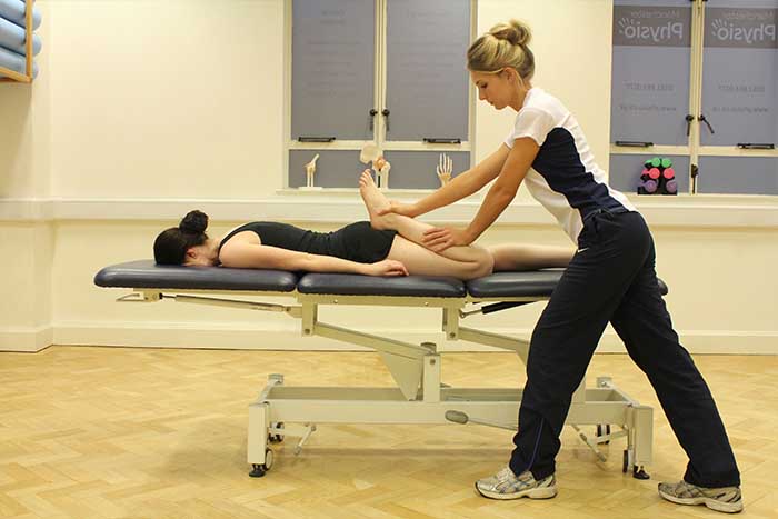 Customer receiving a calf stretch while in a relaxed position in Manchester Physio Clinic Customer receiving a calf stretch while in a relaxed position in Manchester Physio Clinic