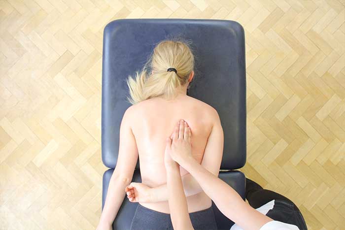 Customer receiving an upper back massage while in a relaxed position in Manchester Physio Clinic Customer receiving an upper back massage while in a relaxed position in Manchester Physio Clinic