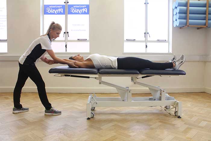 Customer receiving an arm stretch while in a relaxed position in Manchester Physio Clinic Customer receiving an arm stretch while in a relaxed position in Manchester Physio Clinic