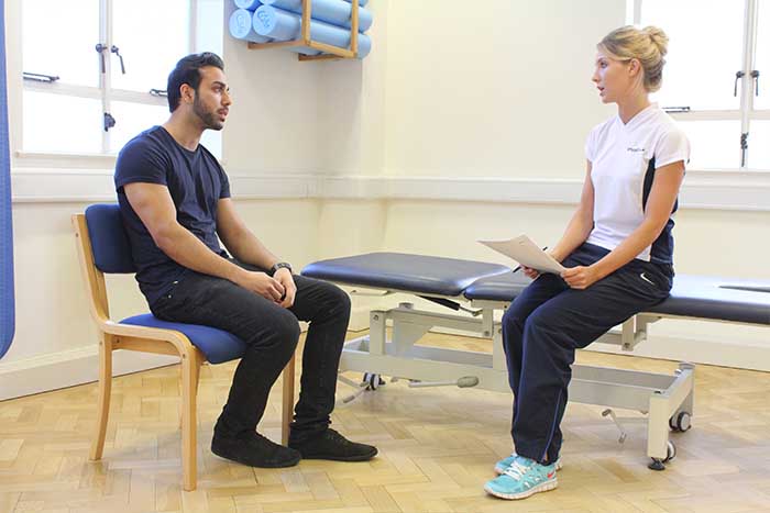 Customer having a conversation with massager in Manchester Physio Clinic Customer having a conversation with massager in Manchester Physio Clinic