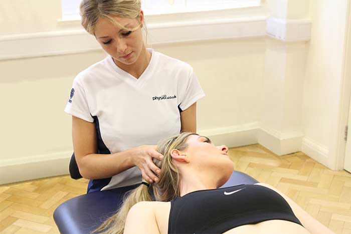 Customer receiving head massage in relaxed position in Manchester Physio Clinic