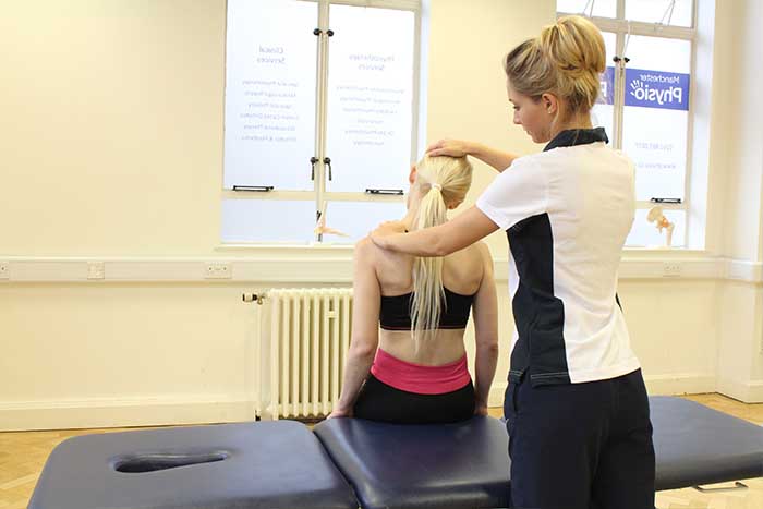 Customer receiving shoulder check in sitting up position in Manchester Physio Clinic Customer receiving shoulder check in sitting up position in Manchester Physio Clinic