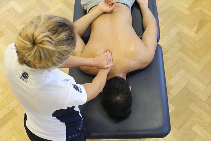 Customer receiving upper back massage in relaxed position in Manchester Physio Clinic