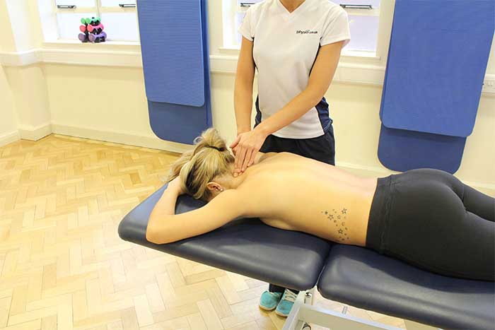 Customer receiving upper back massage while in relaxed position in Manchester Physio Clinic