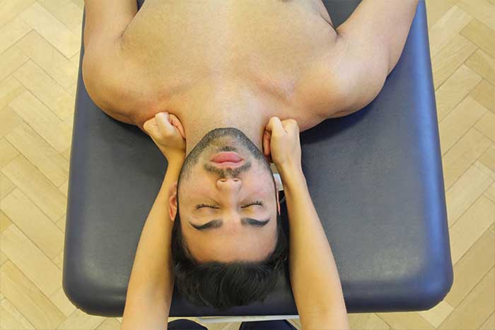 Customer receiving neck massage while in relaxed position in Manchester Physio Clinic Customer receiving neck massage while in relaxed position in Manchester Physio Clinic