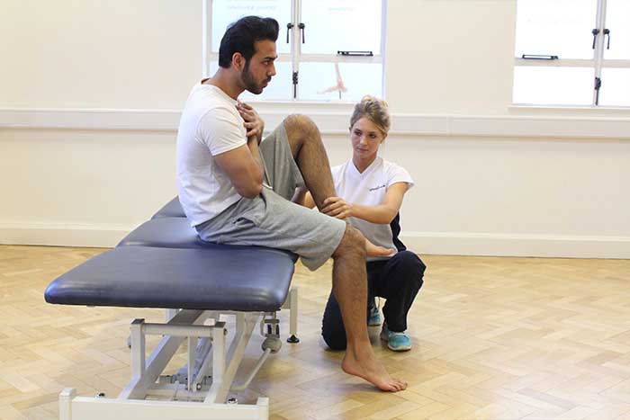 Customer receiving leg stretch while in a sitting position Customer receiving leg stretch while in a sitting position