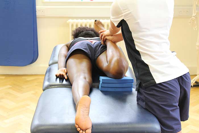 Customer receiving leg stretch while in a relaxed position Customer receiving leg stretch while in a relaxed position