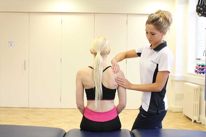 Customer receiving upper shoulder massage while in a sitting up position