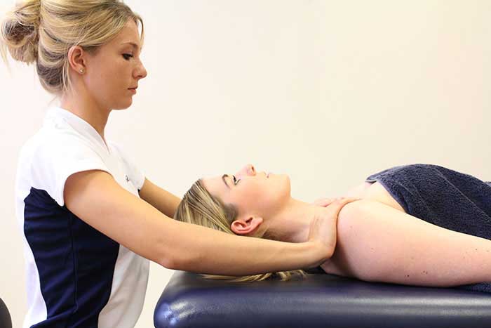 Customer receiving a shoulder massage while in a relaxed position in Manchester Physio Clinic Customer receiving a shoulder massage while in a relaxed position in Manchester Physio Clinic